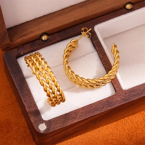 Detail view of gold stainless steel twisted hoop earrings on a velvet jewelry box
