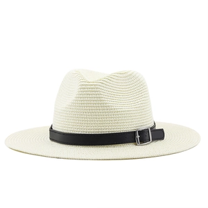 Close-up of woven straw fedora hat texture with black leather band and silver buckle