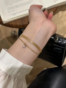 Dettaglio del bracciale a maglia piatta placcato oro 18K e set di catenine con diamante