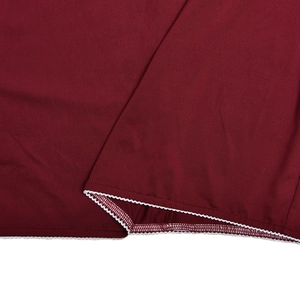 Detail of dark red knit fabric with white zigzag lace trim and neat edge stitching
