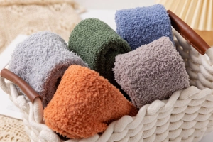 Close-up of colorful coral fleece over-knee socks neatly rolled in a white woven basket