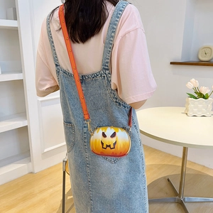 Detail of Halloween pumpkin crossbody bag with adjustable strap worn by model
