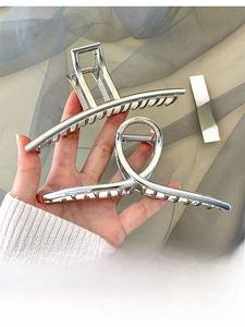 Detail of silver metallic hair claws with rectangular and twisted ring designs