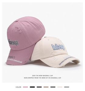 Detailed close-up of washed cotton baseball caps with vintage embroidery and worn-out texture