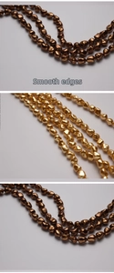 Macro detail of irregular baroque beads with smooth holes and metallic gold finish