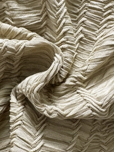 Makrodetail von beigem strukturiertem Stoff mit 3D-Chevron-Muster für Bademode