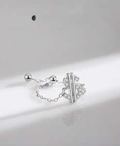 Detailed macro of S925 silver dollar sign ring with sparkling pavé stones and chain