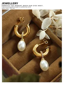 Detailed view of Baroque pearl C-shape earrings with zircon studs in a luxury jewelry box