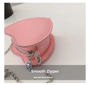 Close-up of pink heart purse showing smooth zipper and silver chain detail