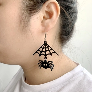 Halloween acrylic spider web drop earrings for men and women worn by a model