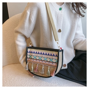 Detailed view of bohemian crossbody bag with colorful tassels and geometric embroidery