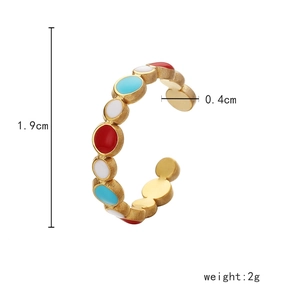 Detail shot of a gold hollow ring featuring colorful red, white, and blue enamel dots