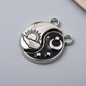 Close-up of Yin Yang Tai Chi alloy charm with black and white enamel and metal hooks