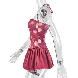 Dettaglio dell'abito rosso scuro con stampa floreale di rose e gonna con volant