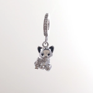 Detailed view of silver cat charm with black enamel eyes and a small fish pendant