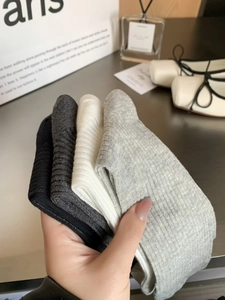 Detail showing four pairs of ribbed knit socks in black, grey, and white cotton blend