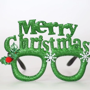 Detail of green glitter Christmas glasses frame with Merry Christmas lettering and holly