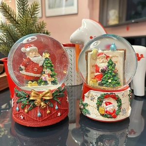 Christmas snow globe music box with Santa and snowman motifs in festive red and green