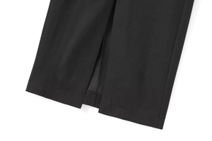 Gros plan d'une robe noire avec fente à l'ourlet et détails de coutures soignées