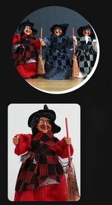 Close-up of hanging Halloween witch ornament with broom and red fabric cloak detail