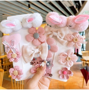 Detailliertes Set aus süßen Plüsch-Hasen-Haarspangen und rosa Haarschmuck für Mädchen
