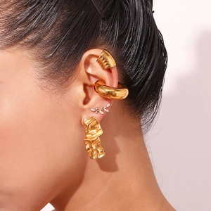 Close-up of vintage 18K gold plated teardrop earrings and layered ear cuff set on model