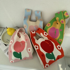 Close-up of four knitted tote bags with floral patterns and vibrant retro colors