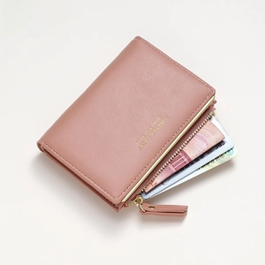 Detail view of pink leather short wallet with card slots and golden zipper pocket
