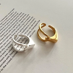 Minimalist 925 sterling silver knotted rings in gold and silver finish on book page