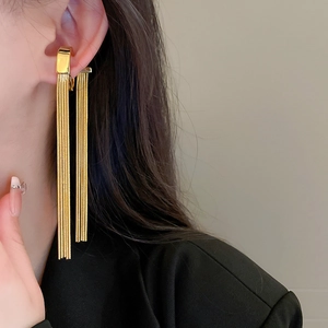 Close-up of golden metal tassel ear clip on model showing elegant fringe details
