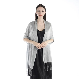 Detail showing elegant silver shimmer shawl with fringe trim on a model black dress