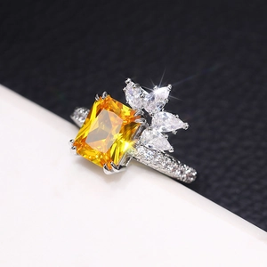 Detail of yellow rectangular gemstone ring with sparkling pear-cut side zircons