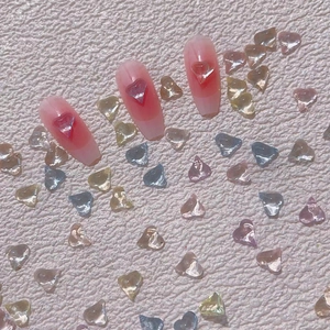 Pink gradient long trapezoid nails with transparent 3D heart charms on leather background