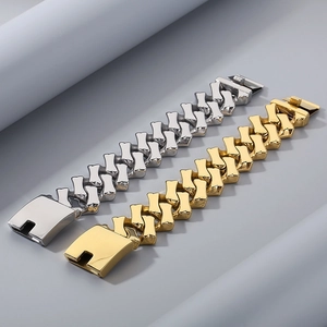 Gros plan de bracelets gourmette en or et argent avec maillons en losange et fermoirs larges