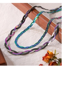 Macro detail of multi-color woven flat snake chains on a wooden tray with a vintage look