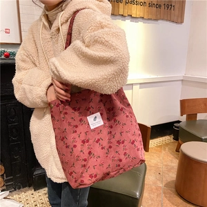 Detalle de bolso tote de pana rosa con flores, textura suave y diseño floral retro