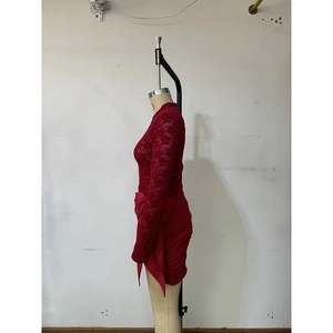 Detail of red lace mini dress featuring side ruching and long ribbon bow accents