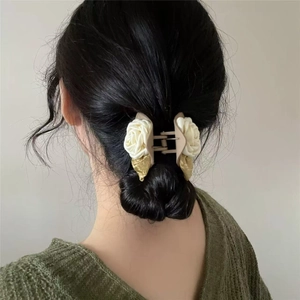 Elegant camellia flower hair claw with white fabric blooms on a ponytail