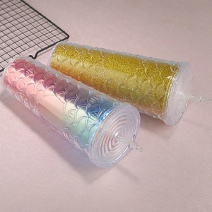 Close-up of glitter fish scale textured reusable tumblers with lids and straws