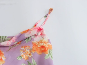 Detail of purple floral spaghetti strap top featuring delicate neckline and soft texture