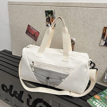 Close-up of beige sports gym bag with grey mesh pocket and adjustable shoulder strap