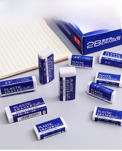Close-up of 2B erasers for sketching and exams on a striped notebook background