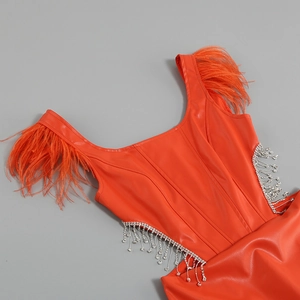 Détail de la robe en cuir PU orange avec bretelles en plumes et glands en strass