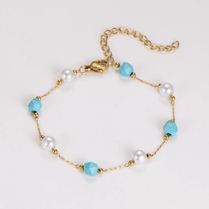 Dettaglio del bracciale a catena dorata con perle e pietre di turchese irregolari