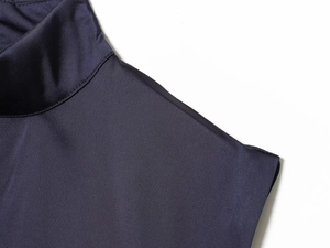 Détail du col montant et de la dentelle sur une mini-robe en satin violet foncé soyeux
