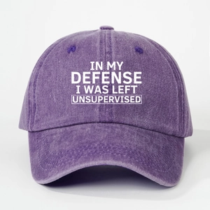 Detailed close-up of purple washed cotton baseball cap with white slogan embroidery