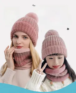 Dettaglio del set cappello e sciarpa in maglia rosa per mamma e bambino