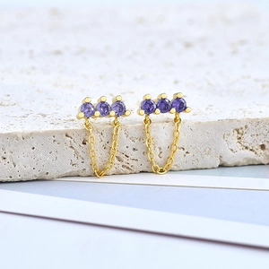 Detail view of gold-plated S925 earrings with three purple stones and delicate chains
