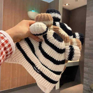 Close-up of the knitted earflap hat showing the soft striped texture and cute ear design
