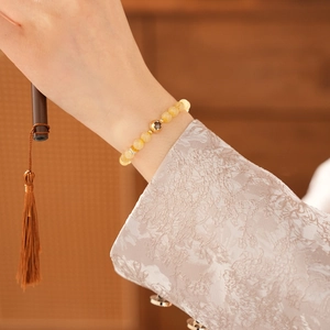 Detail of yellow citrine bead bracelet with gold clover hollow bead on wrist